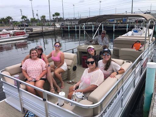 A family smiles aboard a pontoon, poised for a day of fun, highlighting family pontoon rentals.