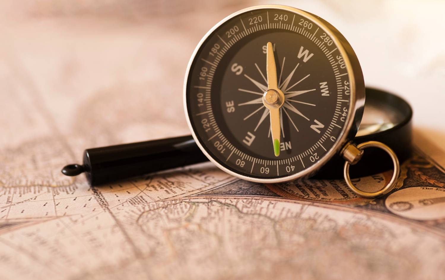 A classic compass over a vintage map, symbolic for travel and navigation.