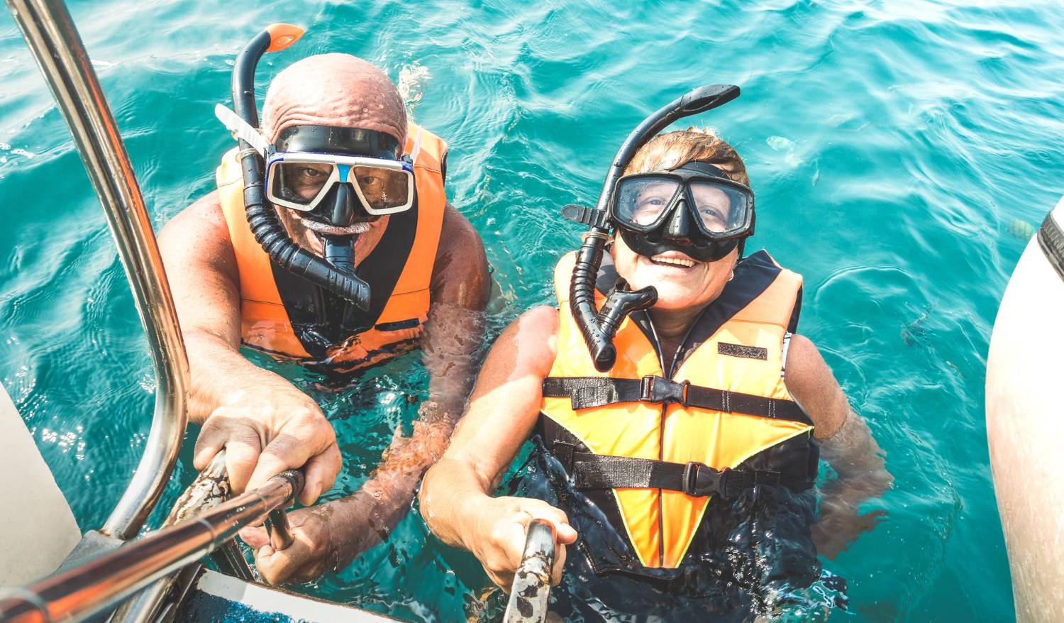 Ex"Two snorkelers in life jackets smiling eagerly before their dolphin encounter adventure at sea."tending Your Adventure