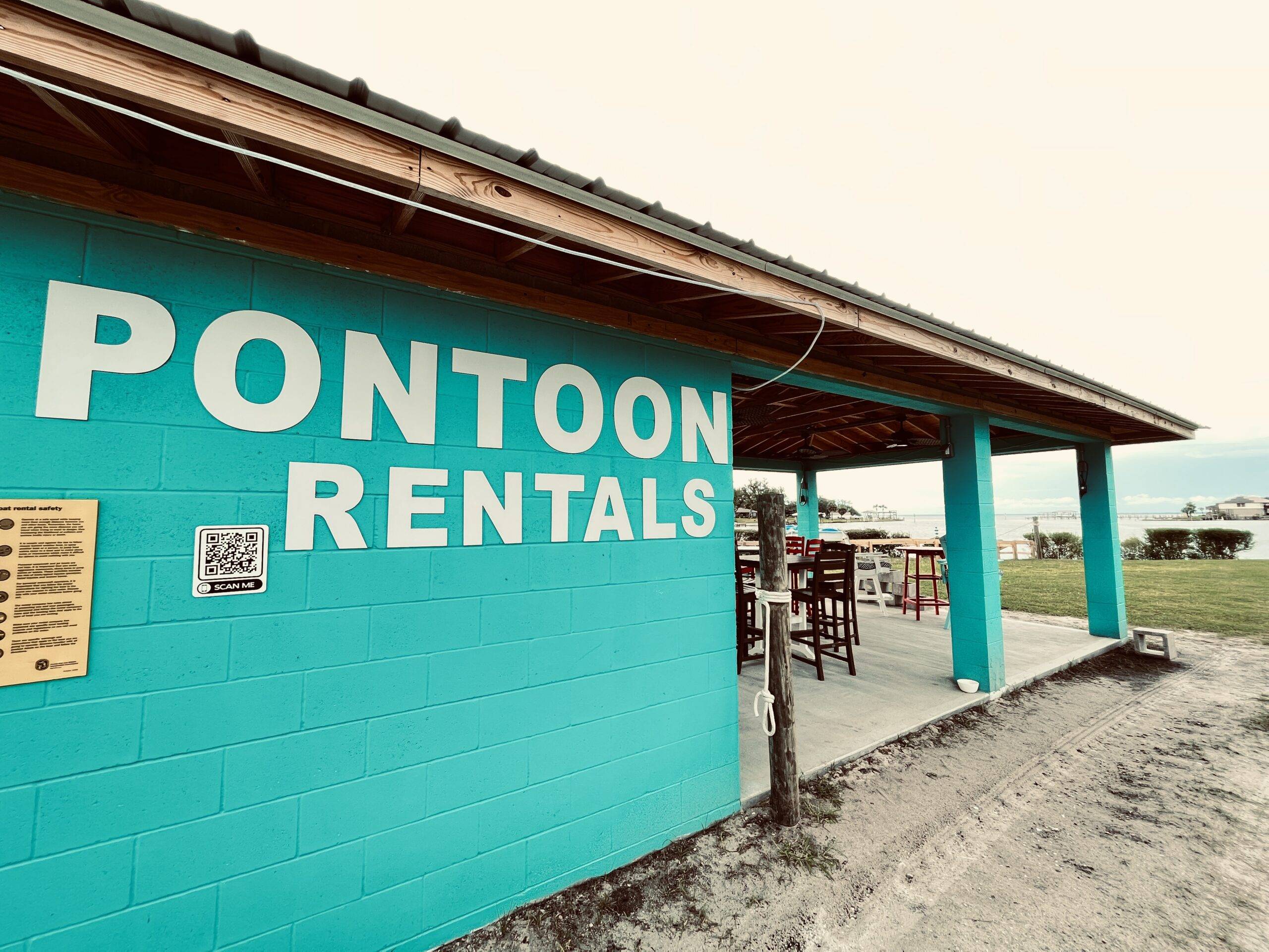 Vibrant turquoise shack advertising Pontoon Rentals, inviting you to aquatic adventures.