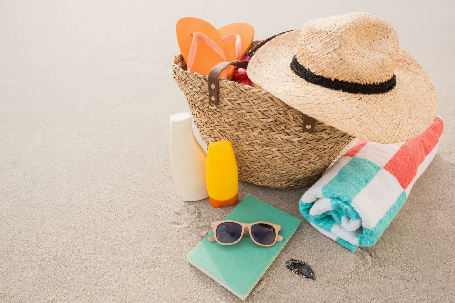 Beach essentials with a straw hat, suggesting a sunny day planned with a Panama City pontoon rental.