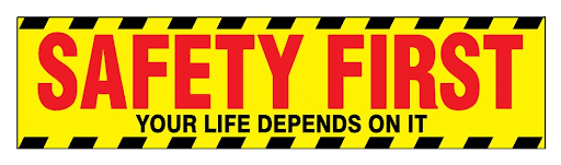Yellow and red "SAFETY FIRST - YOUR LIFE DEPENDS ON IT" sign with caution stripes, promoting vigilant safety measures.