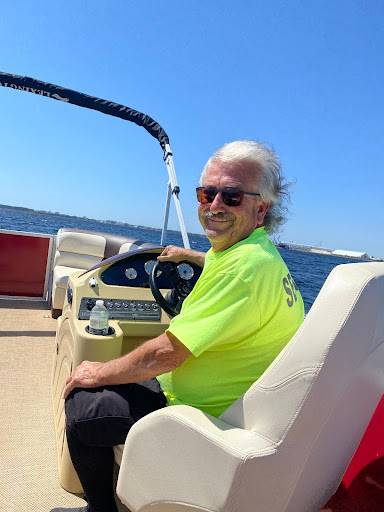 A senior steering a pontoon boat with joy, epitomizing fun family pontoon rentals.