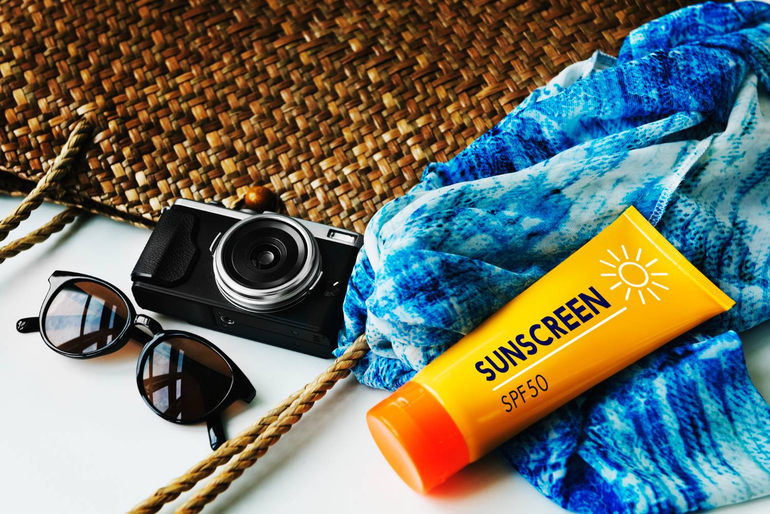 "Essentials for a day at sea: sunscreen SPF50, camera, sunglasses, and a vibrant blue scarf for dolphin encounters."